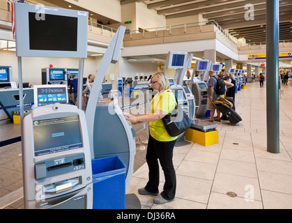 Calgary Donna che utilizza Controllo automatico in macchine aeroporto sala Partenze Aeroporto Internazionale di Calgary Alberta Canada Foto Stock