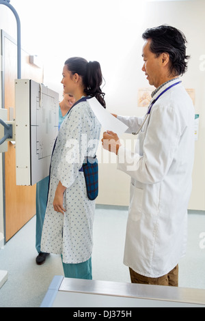 Medico preparazione paziente per raggi X al torace Foto Stock