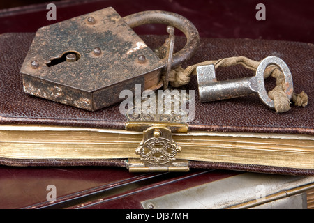 Lucchetto e chiave su molto vecchi libri bloccati Foto Stock