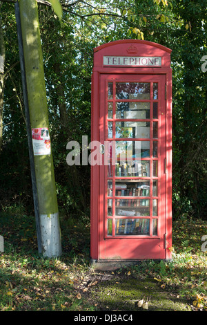 Un tradizionale rosso inglese cabina telefonica trasformata in un villaggio di libreria per memorizzare libri riutilizzabili. Foto Stock