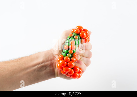 Maschio di spremitura a mano palla su sfondo semplice Foto Stock