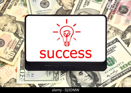 Tavoletta digitale con simbolo di successo sullo sfondo di dollari Foto Stock