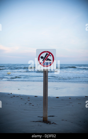 Un nessun segno di nuoto su una spiaggia al tramonto in Galveston, Texas, Stati Uniti d'America. Foto Stock