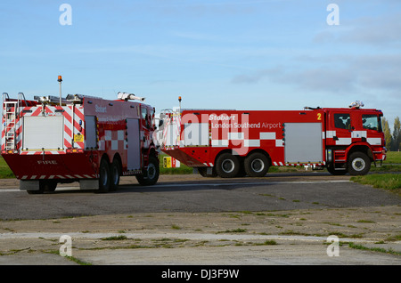 Aeroporto di due motori Fire unità fuori all'aeroporto di rullaggio che conduce alla pista su una esecuzione pratica. Londra aeroporto di Southend veicoli di emergenza Foto Stock