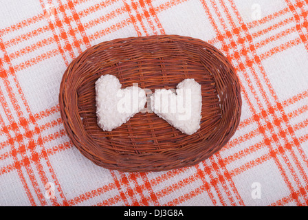 I cookie in forma di cuori nel cestello sulla tovaglia. Foto Stock