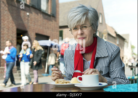 Donna con caffè e torta Foto Stock