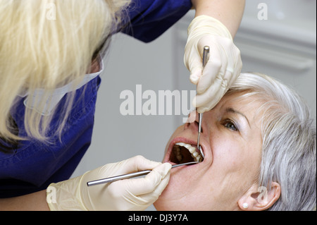 Controllo dei denti da parte di un assistente dentale Foto Stock