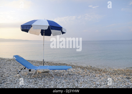 Liegestuhl und ombrellone am Strand Foto Stock