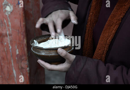 Lhasa, in Tibet. Xxi Nov, 2013. Giovane monaco Soinam Gyaco prepara tsamba, o torrefatto Orzo highland con burro, per la sua prima colazione al Gonggar Qoide Monastero a Gonggar contea del sud-ovest della Cina di regione autonoma del Tibet, nov. 20, 2013. Soinam Gyaco, 19, è il figlio di una famiglia dell'agricoltore nei pressi del monastero. Azionato dalla sua fede buddista, ha scelto la vita di un monaco Gonggar Qoide monastero dopo finitura di alta scuola. Credito: Xinhua/Alamy Live News Foto Stock