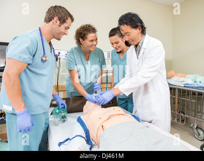 Il team medico di tubo di regolazione nel fantoccio della bocca del paziente Foto Stock