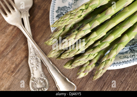 Gli asparagi spears su una piastra di antiquariato e argento antico forche Foto Stock