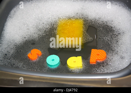 Lettere di giocattoli galleggianti in lavaggio fino bacino ortografia della parola soap Foto Stock