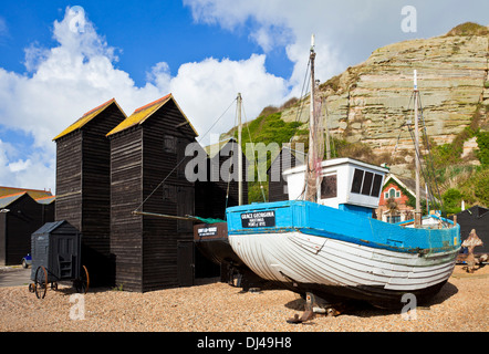 Neri alti tradizionale rete capannoni di asciugatura sulla spiaggia con barche da pesca a Hastings East Sussex England Regno Unito GB EU Europe Foto Stock