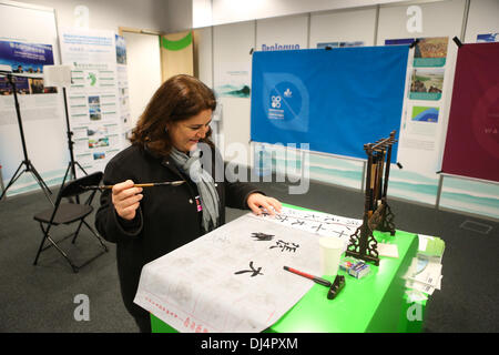 Varsavia, Polonia. Xxi Nov, 2013. Un delagate tenta la calligrafia cinese al padiglione cinese durante il 2013 la Conferenza delle Nazioni Unite sui cambiamenti climatici a Varsavia, Polonia, il nov. 21, 2013. Sipario sulla 7-giorno Cina padiglione presso il 2013 delle Nazioni Unite sui Cambiamenti Climatici parla di giovedì, che ha montrato 17 eventi tra cui forum e mostre caratterizzanti della Cina di sforzi e i risultati conseguiti per affrontare il cambiamento climatico. Credito: Zhang ventola/Xinhua/Alamy Live News Foto Stock