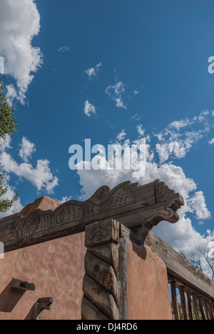 Una parete di adobe che è decorato con fantasiosi intarsi in legno nel tradizionale southwestern stile USA a Santa Fe, New Mexico. Foto Stock