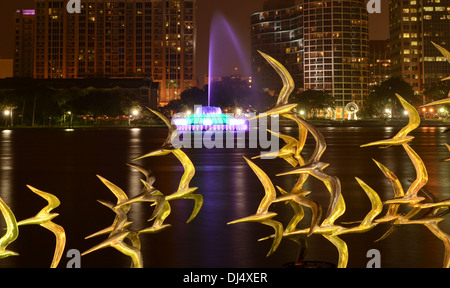 Vedere Arte Scultura Orlando " prendere il volo' dall'artista Douwe Blumberg sul Lake Eola con il centro cittadino di Orlando, Florida e fontana. Foto Stock