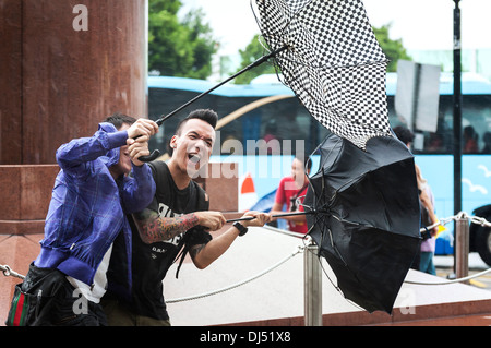 Ragazzi locale divertendosi nel vento come Typhoon Usagi si avvicina a Hong Kong Foto Stock