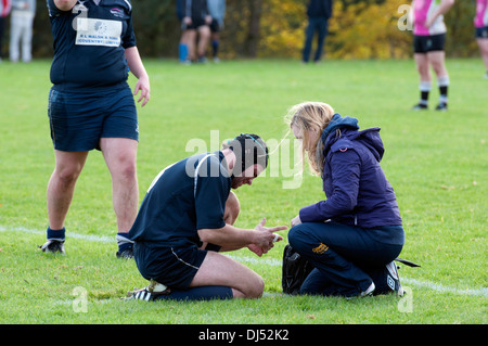 Università sport, uomini Rugby Union, feriti giocatore riceve il primo soccorso. Foto Stock