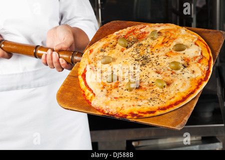 Lo Chef tenendo la Pizza sulla pala Foto Stock