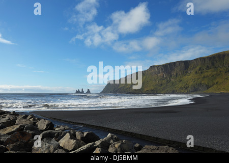 Lava nera Beach con il basalto di pile di Reynisdrangar in background; Vik, Vestur-Skaftafellssysla, Islanda Foto Stock