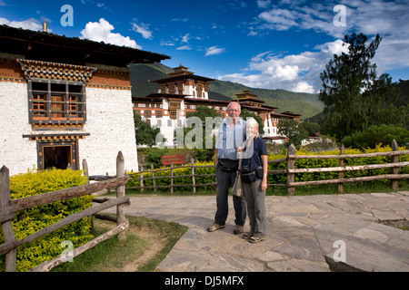 Il Bhutan, Punakha Dzong, senior i turisti occidentali che posano per una foto ricordo Foto Stock