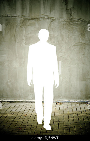 Spaccato di un imprenditore silhouette in distressed muro grigio Foto Stock