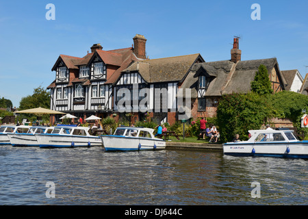 Barche ormeggiate sul fiume Bure, The Swan Inn Public House e ristorante, Horning, Norfolk, Inghilterra, Regno Unito, Gran Bretagna, Europa Foto Stock