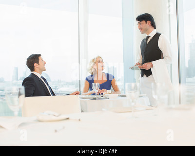 La gente di affari di parlare al cameriere del ristorante Foto Stock