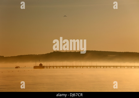 Yarmouth Pier e il mare di Yarmouth in early morning light foschia marina Yarmouth Isle of Wight Hampshire Inghilterra Foto Stock