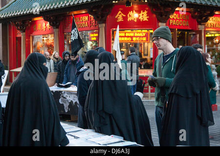 Londra, 22 novembre 2013. Le donne musulmane di parlare a un passerby come radicale predicatore islamico Anjem Choudary's Islam4UK tenere una protesta e volantinaggio ad ampio raggio per il pubblico a Chinatown per evidenziare la persecuzione dei musulmani in Cina. Credito: Paolo Davey/Alamy Live News Foto Stock