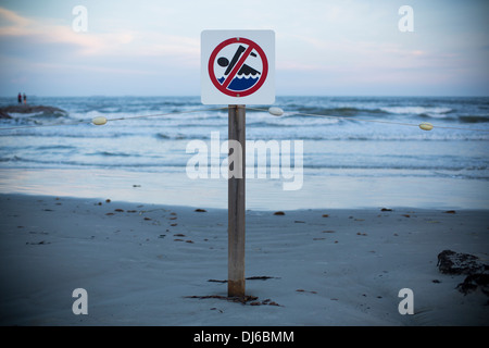 Un nessun segno di nuoto su una spiaggia al tramonto in Galveston, Texas, Stati Uniti d'America. Foto Stock