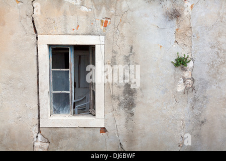 Edificio abbandonato con pareti incrinate e aprire la finestra Foto Stock