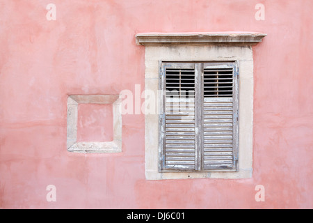 Rosa costruzione fortificata con parzializzato chiusa la finestra in legno Foto Stock