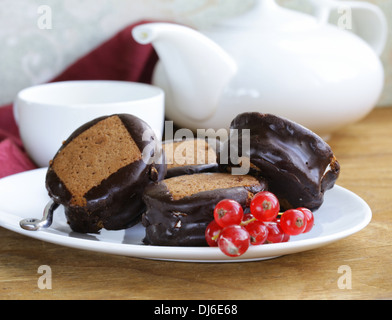 Il cioccolato mini torte decorate con uve secche di Corinto su una piastra bianca Foto Stock