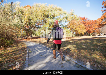 Uno studente di college passeggiate alla classe in un parco di Boston. Foto Stock