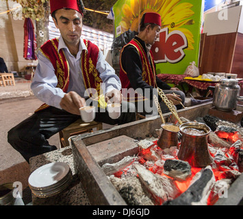 Servire il caffè turco tradizionalmente. Un bagno turco barista si prepara a mano due fumanti tazze di caffè per patroni Foto Stock