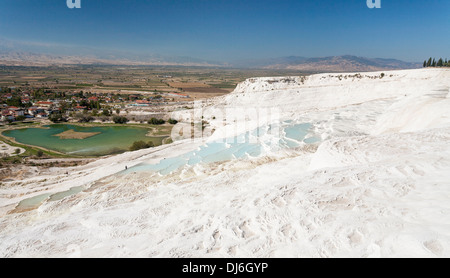 La vista dalla cima di Pamukkale. La città e le montagne al di là. Piscine formata facendo precipitare il calcio Foto Stock