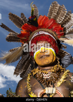 Uomo tribale con la faccia di vernice e di selvaggina di penna copricapo a Goroka Show singsing festival, Goroka, Papua Nuova Guinea Foto Stock