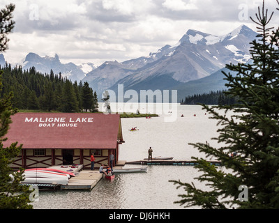 Il Lago Maligne Boat House e canoisti. Rematori stabiliti dal vecchio boathouse per una vista panoramica delle montagne dal lago. Foto Stock