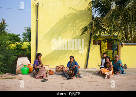 Rurale villaggio indiano di donne e ragazze sat in strada in una zona rurale villaggio indiano. Andhra Pradesh, India Foto Stock