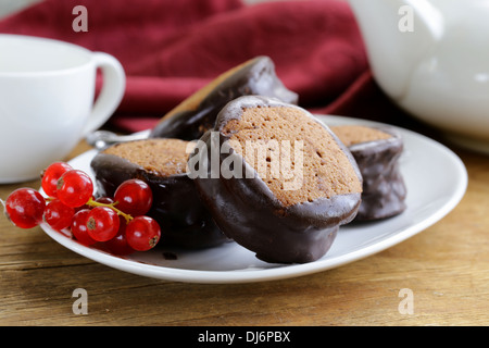 Il cioccolato mini torte decorate con uve secche di Corinto su una piastra bianca Foto Stock