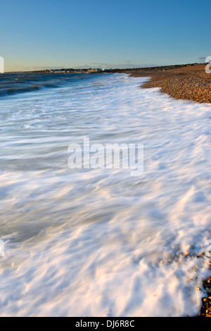 Le onde di colpire la spiaggia su Hurst allo spiedo, Milford-on-Sea, Hampshire al tramonto Foto Stock