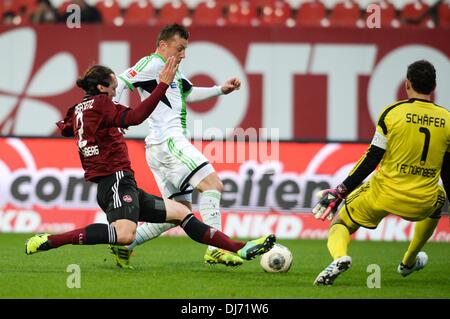 Norimberga, Germania. 23 Nov, 2013. Di Norimberga Emanuel Pogatetz (L) il sistema VIES per la palla con il Wolfsburg Ivica OLIC davanti a Norimberga il portiere Raphael Schaefer (R) durante la Bundesliga soccer mathc tra fc e Norimberga VfL Wolfsburg a Grundig Stadion di Norimberga, Germania, 23 novembre 2013. Foto: ARMIN WEIGEL/dpa (ATTENZIONE: grazie alle linee guida di accreditamento, il DFL consente solo la pubblicazione e utilizzazione di fino a 15 immagini per corrispondenza su internet e nei contenuti multimediali in linea durante la partita.)/dpa/Alamy Live News Foto Stock