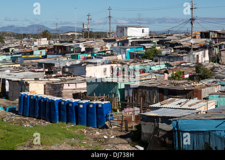 Sud Africa, Cape Town, Khayelitsha Township. Blu bagni portatili in primo piano. Foto Stock