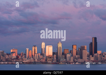 La città di Seattle skyline attraverso Elliot Bay al tramonto, come visto da ovest a Seattle, Washington. Foto Stock