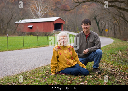 Novantenne Donna e figlio che posano per una foto davanti alla Busching ponte coperto in Ripley County, Indiana Foto Stock