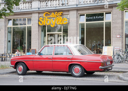 Cafe Sibylle, Karl Marx Allee Street, a Berlino e in Germania con il vecchio rosso auto Mercedes Foto Stock