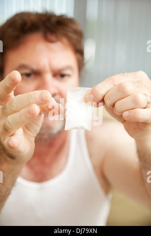 Tossicodipendente tenendo un grammo di cocaina. **Drammatizzazione - assenza di droghe illegali sono stati utilizzati per la realizzazione di questa fotografia** Foto Stock