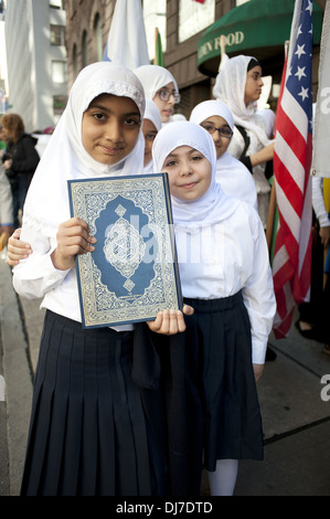 Musulmano annuale parata del giorno, New York City, 2012. Da studentessa di scuola musulmana in Queens conserva copia del Corano. Foto Stock