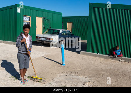 Giovane donna ampie intorno alla comunità acqua tocca, Sud Africa, Cape Town, Khayelitsha Township. Foto Stock